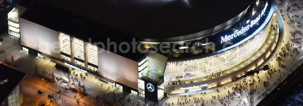 Berlin at night from the bird perspective: Night view of Mercedes-Benz-Arena on the Spree riverbank in the Friedrichshain part of Berlin. The former O2 World - now Mercedes-Benz-Arena - is located in the Anschutz Areal, a business and office space on the riverbank