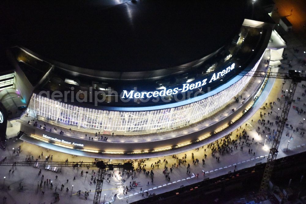 Berlin at night from above - Night view of Mercedes-Benz-Arena on the Spree riverbank in the Friedrichshain part of Berlin. The former O2 World - now Mercedes-Benz-Arena - is located in the Anschutz Areal, a business and office space on the riverbank