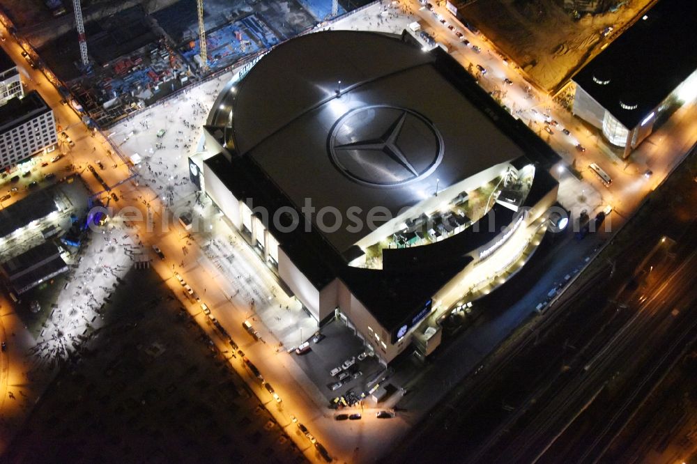 Berlin at night from the bird perspective: Night view of Mercedes-Benz-Arena on the Spree riverbank in the Friedrichshain part of Berlin. The former O2 World - now Mercedes-Benz-Arena - is located in the Anschutz Areal, a business and office space on the riverbank