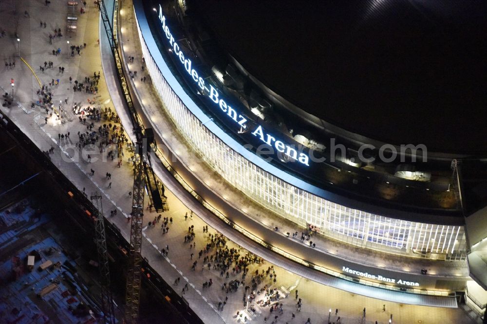 Berlin at night from above - Night view of Mercedes-Benz-Arena on the Spree riverbank in the Friedrichshain part of Berlin. The former O2 World - now Mercedes-Benz-Arena - is located in the Anschutz Areal, a business and office space on the riverbank