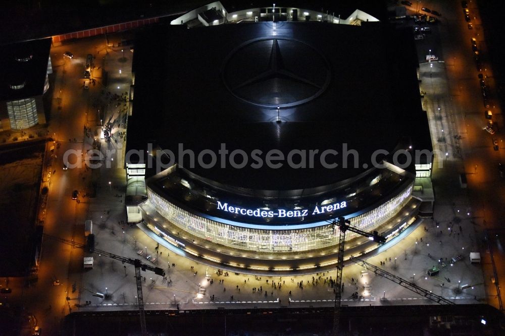 Berlin at night from above - Night view of Mercedes-Benz-Arena on the Spree riverbank in the Friedrichshain part of Berlin. The former O2 World - now Mercedes-Benz-Arena - is located in the Anschutz Areal, a business and office space on the riverbank