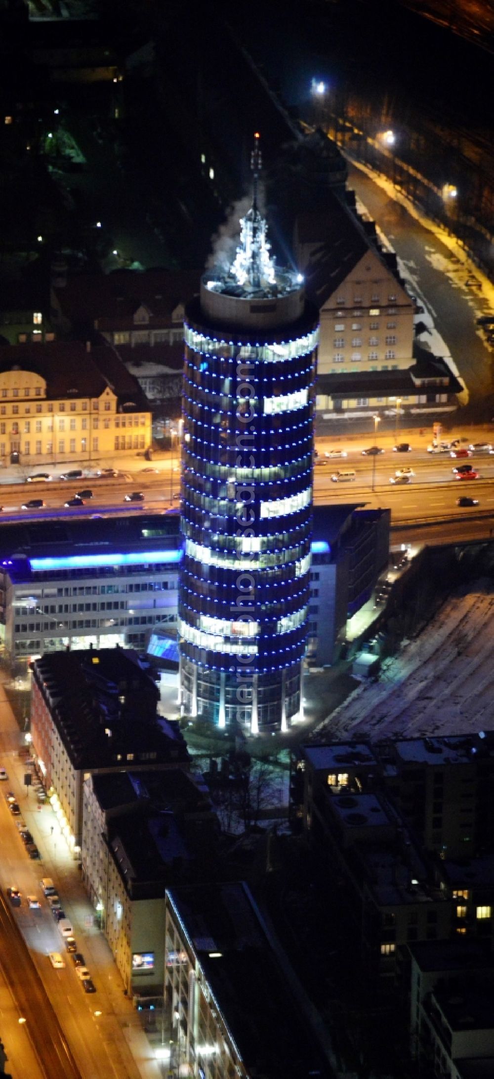 Aerial image at night München - Night aerial view of the blue illuminated skyscraper Central Tower in Munich in Bavaria