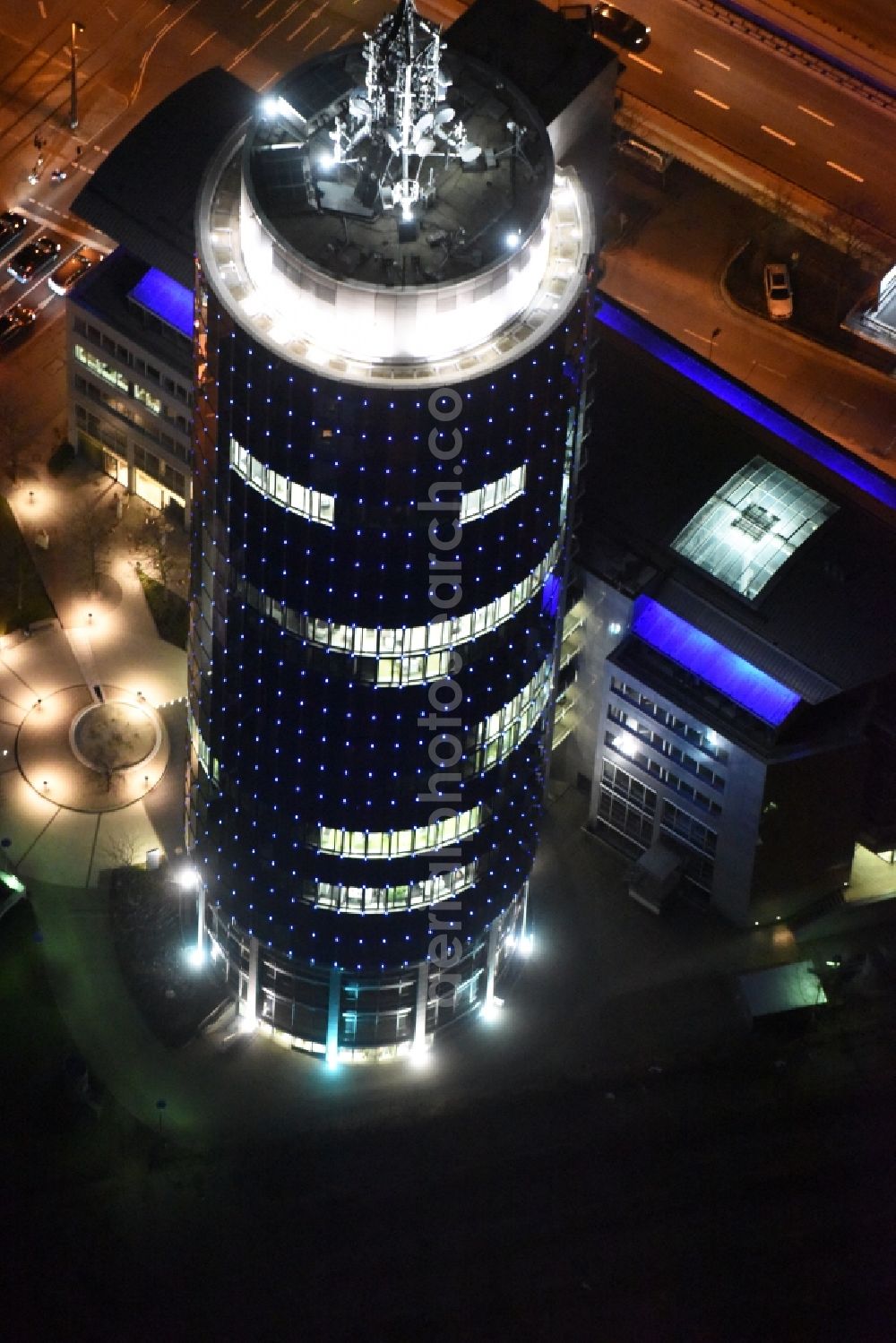 München at night from the bird perspective: Night aerial view of the blue illuminated skyscraper Central Tower in Munich in Bavaria