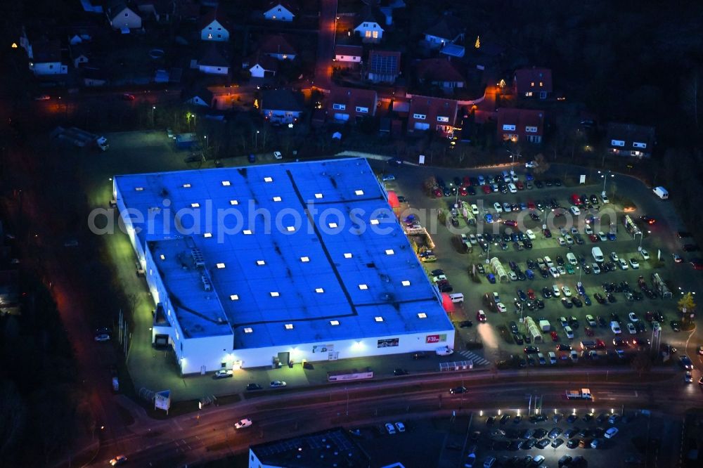 Neuruppin at night from the bird perspective: Night lighting Building of the shopping center of real GmbH on Babimost- Ring in Neuruppin in the state Brandenburg, Germany