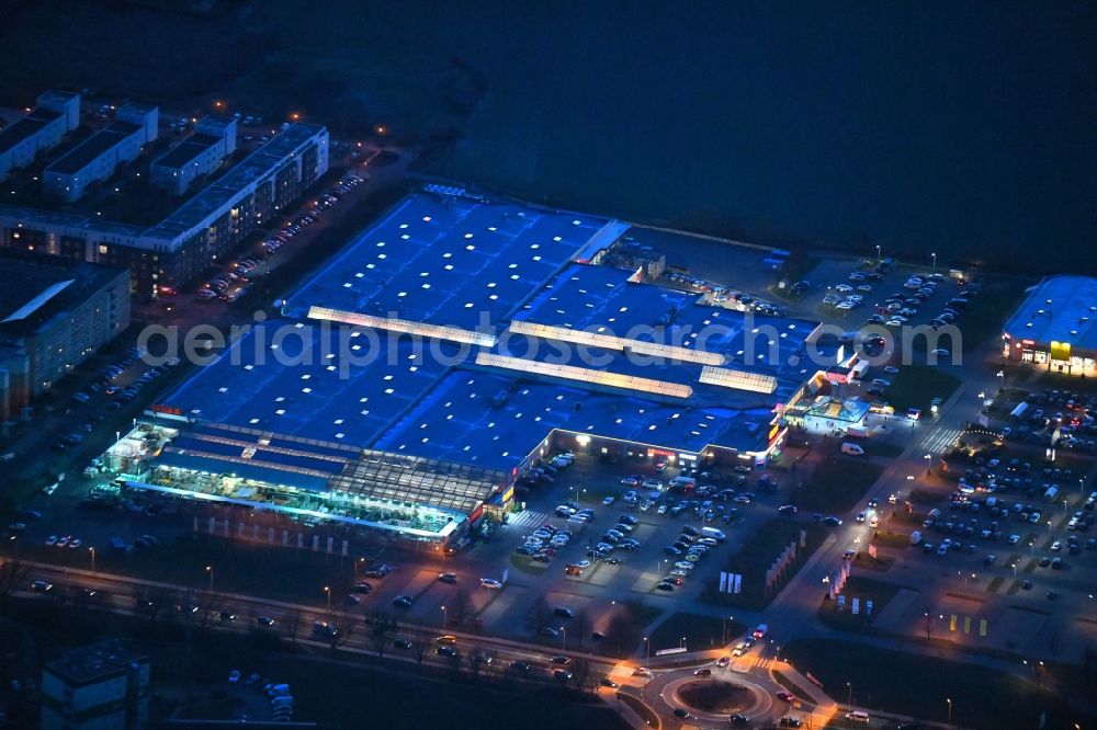 Neuruppin at night from above - Night lighting Building of the shopping center Reiz Ruppiner Einkaufszentrum on Junckerstrasse in Neuruppin in the state Brandenburg, Germany