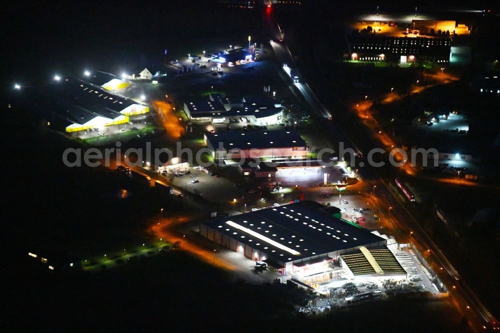 Aerial photograph at night Wittstock/Dosse - Night lighting Building of the construction market of hagebaumarkt wittstock GmbH + Co. KG on Uetersener Strasse in Wittstock/Dosse in the state Brandenburg, Germany