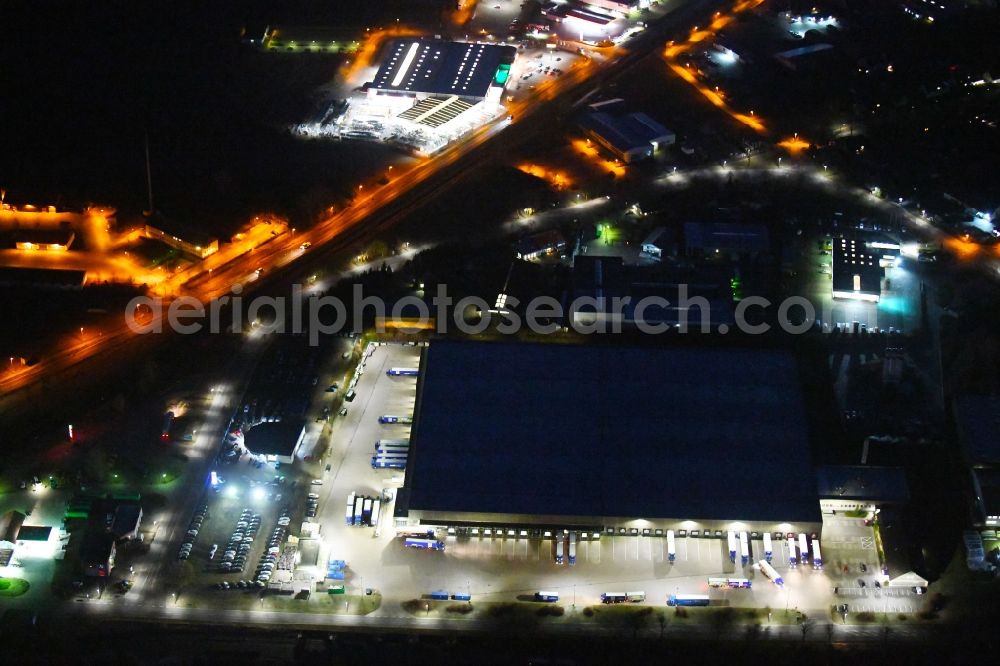 Wittstock/Dosse at night from the bird perspective: Night lighting Building complex and grounds of the logistics center of ALDI GmbH & Co. Kommandit- gesellschaft on Jabeler Chaussee in Wittstock/Dosse in the state Brandenburg, Germany