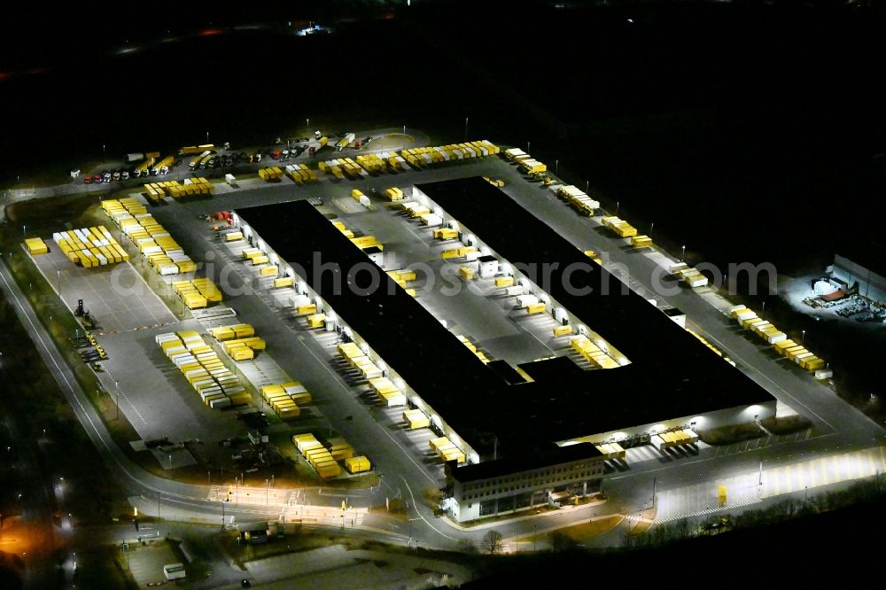 Nohra at night from the bird perspective: Night lighting Building complex and grounds of the logistics center of DHL Paket GmbH on Stangenallee in Nohra in the state Thuringia, Germany