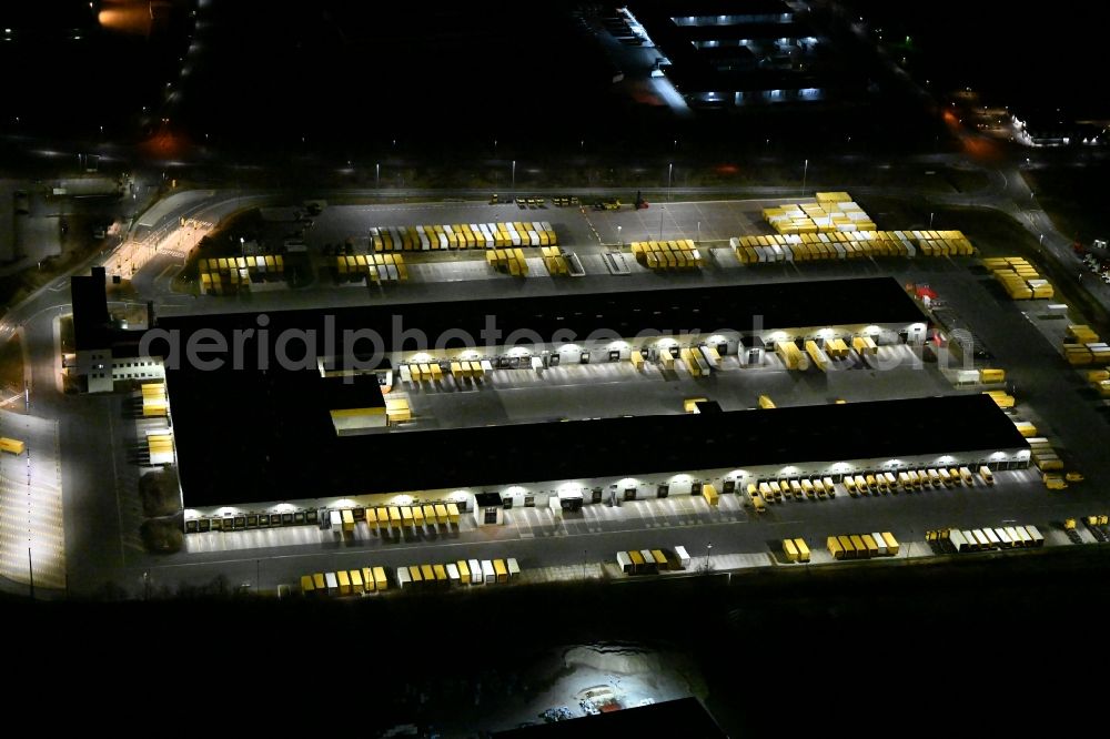 Nohra at night from the bird perspective: Night lighting Building complex and grounds of the logistics center of DHL Paket GmbH on Stangenallee in Nohra in the state Thuringia, Germany