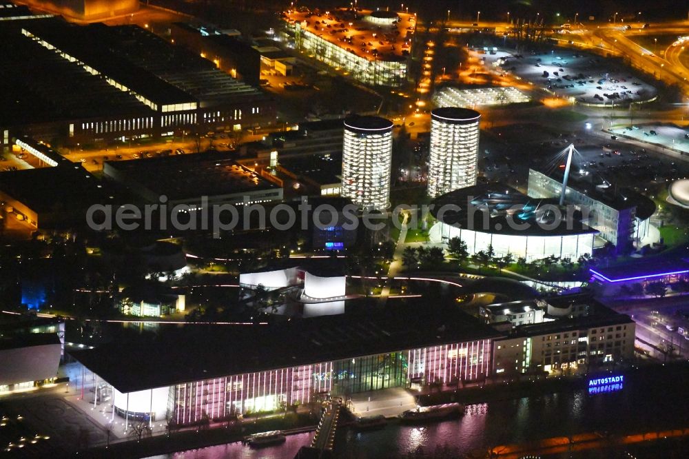 Wolfsburg at night from the bird perspective: Night lighting Building complex and grounds of the logistics center and leisure area of Autostadt of VW in Wolfsburg in the state of Lower Saxony