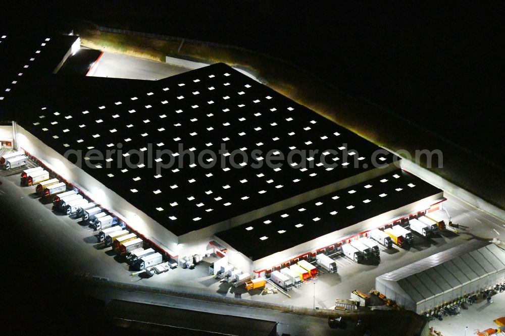 Nohra at night from the bird perspective: Night lighting Building complex and grounds of the logistics center of GC Grosshandels Contor GmbH on Oesterholzstrasse in Nohra in the state Thuringia, Germany