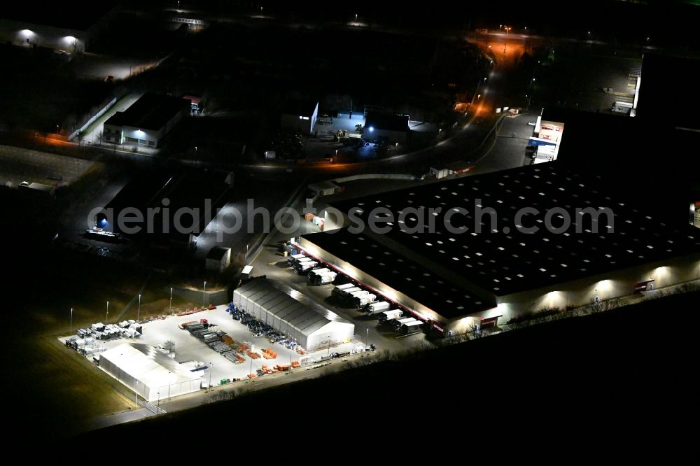 Nohra at night from the bird perspective: Night lighting Building complex and grounds of the logistics center of GC Grosshandels Contor GmbH on Oesterholzstrasse in Nohra in the state Thuringia, Germany