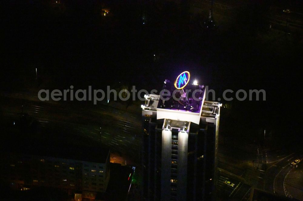 Aerial photograph at night Leipzig - Night lighting the fair logotype neon sign on the roof of the High-Rise building complex of the headquarters of the Leipziger Wohnungs- und Baugesellschaft (LWB) on Wintergartenhochhaus - skyscraper in Leipzig in Saxony