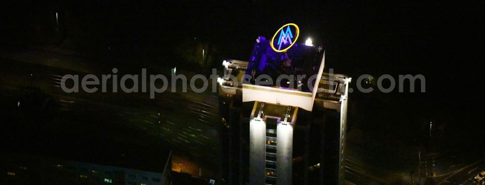 Aerial image at night Leipzig - Night lighting the fair logotype neon sign on the roof of the High-Rise building complex of the headquarters of the Leipziger Wohnungs- und Baugesellschaft (LWB) on Wintergartenhochhaus - skyscraper in Leipzig in Saxony