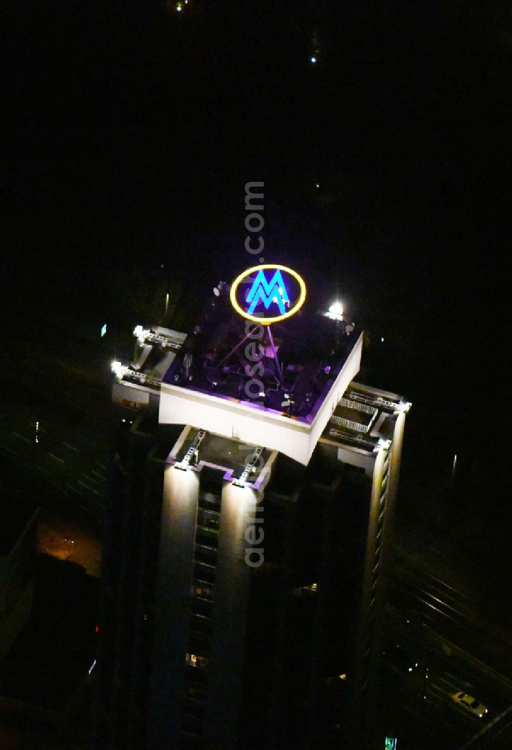 Leipzig at night from above - Night lighting the fair logotype neon sign on the roof of the High-Rise building complex of the headquarters of the Leipziger Wohnungs- und Baugesellschaft (LWB) on Wintergartenhochhaus - skyscraper in Leipzig in Saxony