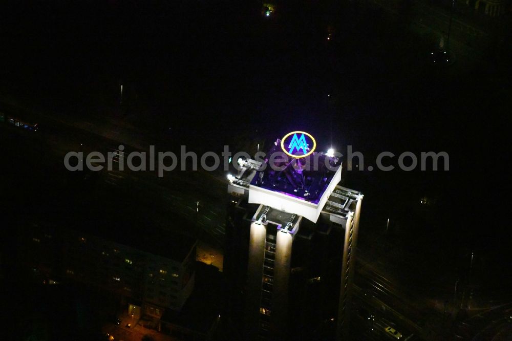 Leipzig at night from the bird perspective: Night lighting the fair logotype neon sign on the roof of the High-Rise building complex of the headquarters of the Leipziger Wohnungs- und Baugesellschaft (LWB) on Wintergartenhochhaus - skyscraper in Leipzig in Saxony