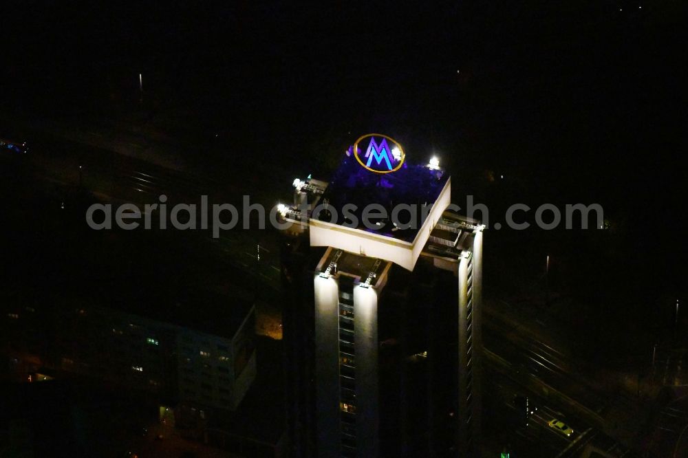 Aerial photograph at night Leipzig - Night lighting the fair logotype neon sign on the roof of the High-Rise building complex of the headquarters of the Leipziger Wohnungs- und Baugesellschaft (LWB) on Wintergartenhochhaus - skyscraper in Leipzig in Saxony