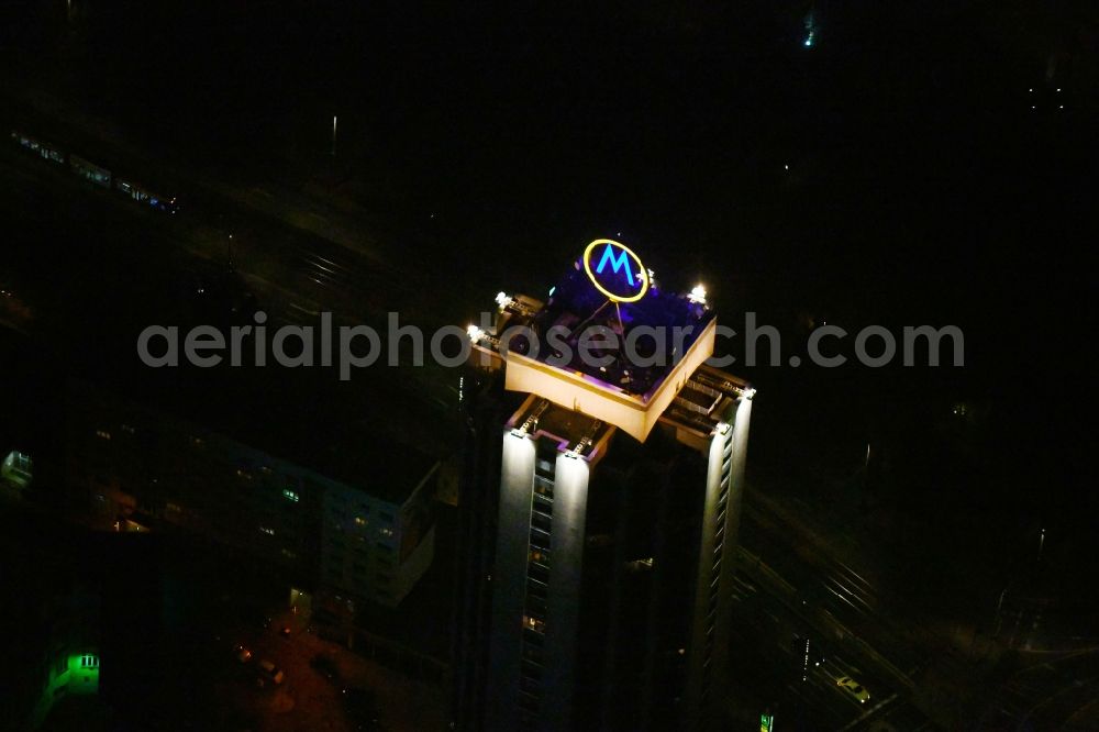 Aerial image at night Leipzig - Night lighting the fair logotype neon sign on the roof of the High-Rise building complex of the headquarters of the Leipziger Wohnungs- und Baugesellschaft (LWB) on Wintergartenhochhaus - skyscraper in Leipzig in Saxony