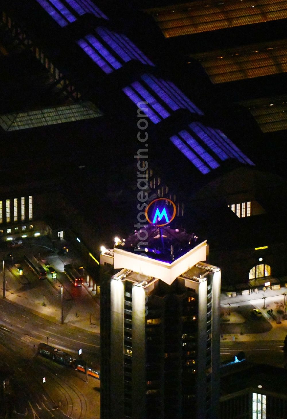 Leipzig at night from the bird perspective: Night lighting the fair logotype neon sign on the roof of the High-Rise building complex of the headquarters of the Leipziger Wohnungs- und Baugesellschaft (LWB) on Wintergartenhochhaus - skyscraper in Leipzig in Saxony