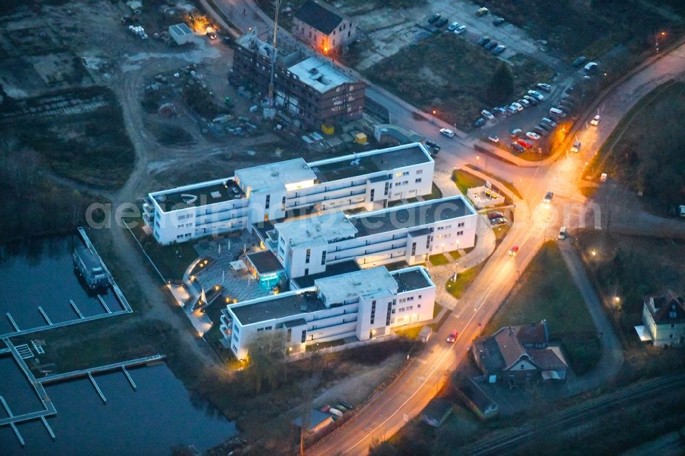 Neuruppin at night from the bird perspective: Night lighting Construction site of a new build retirement home Seetor Residenz between Seedamm and An der Seepromenade in Neuruppin in the state Brandenburg, Germany