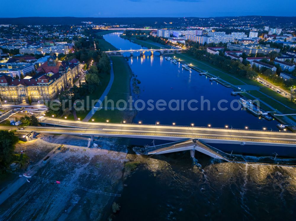 Dresden at night from the bird perspective: Night lighting concrete segments of the collapsed river bridge structure for crossing the Elbe Carolabruecke on the street Carolabruecke in Dresden in the federal state of Saxony, Germany, have fallen down into the riverbed of the Elbe