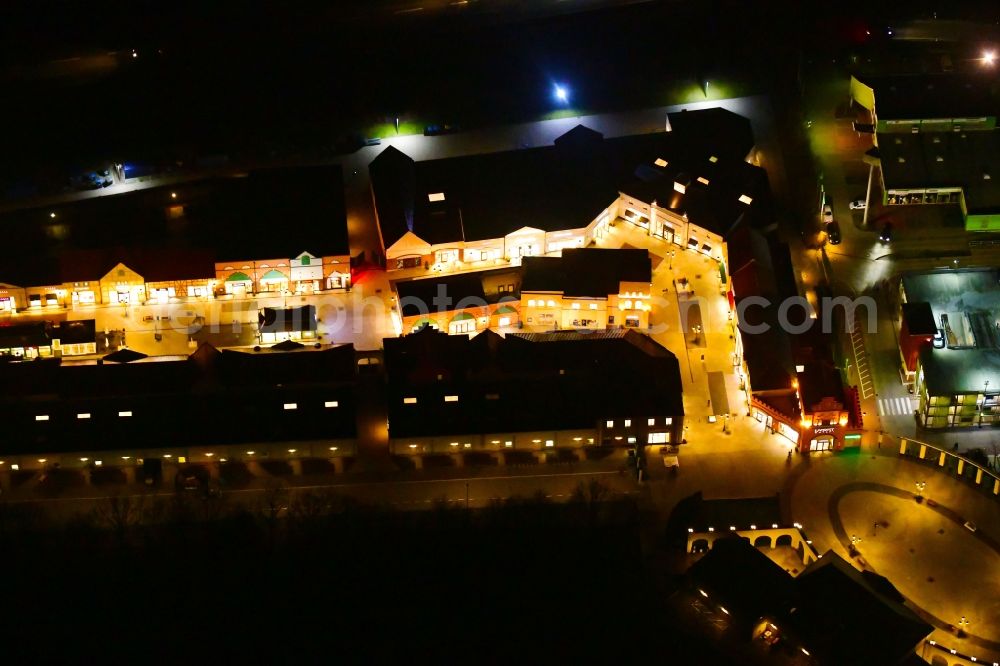 Aerial image at night Wustermark - Night lighting building of the shopping center Designer Outlet Berlin in Wustermark in the state Brandenburg, Germany