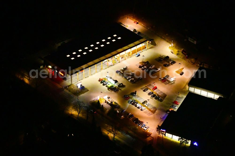 Hohen Neuendorf at night from the bird perspective: Night lighting building of the shopping center on Schoenfliesser Strasse in Hohen Neuendorf in the state Brandenburg, Germany