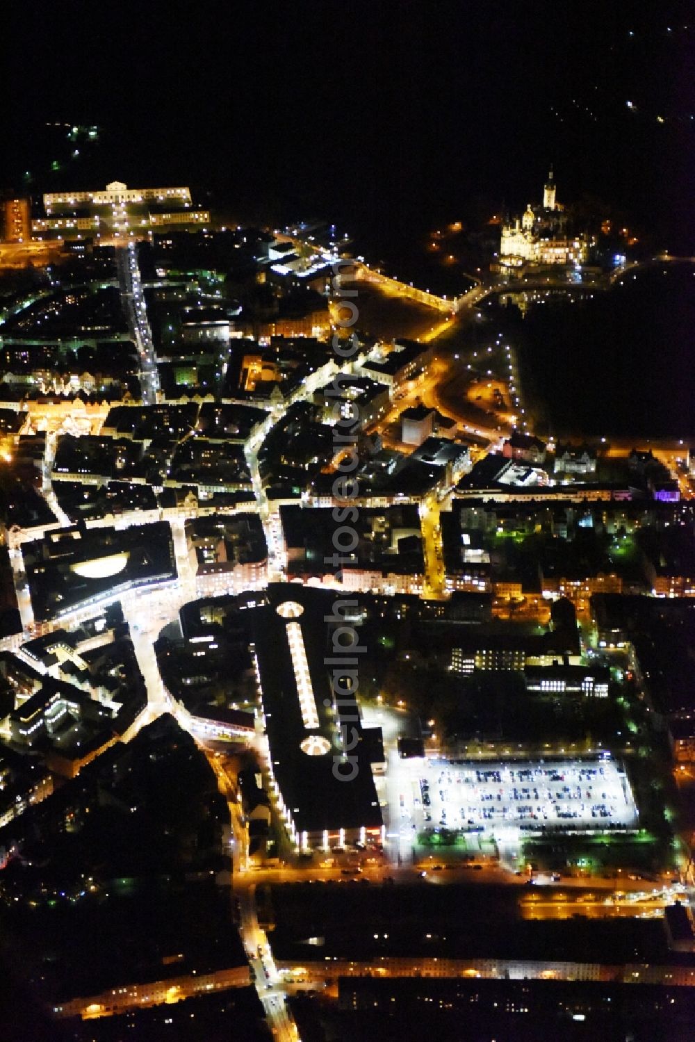 Schwerin at night from the bird perspective: Night view cityscape of downtown at the Marienplatz with the shopping center Castle Park Center of the ECE group and the Marienplatz-Galerie in Schwerin in Mecklenburg - Western Pomerania