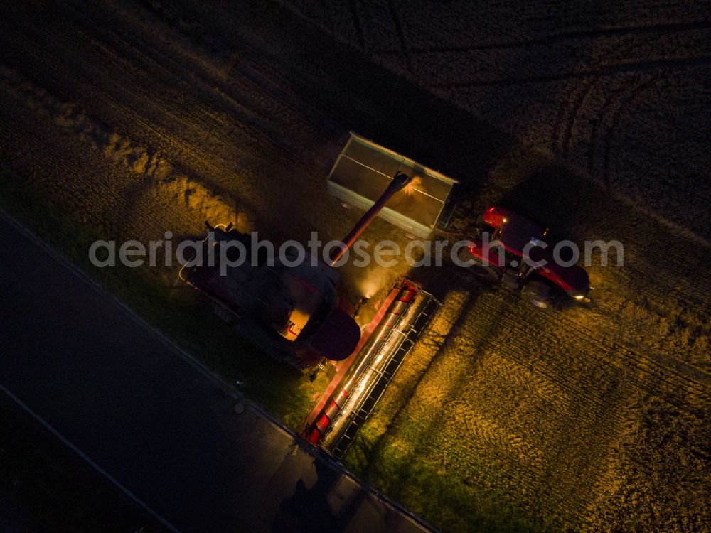 Bannewitz at night from above - Night lighting harvest use of heavy agricultural machinery - combine harvesters and harvesting vehicles on agricultural fields on street Alter Postweg in Bannewitz in the state Saxony, Germany