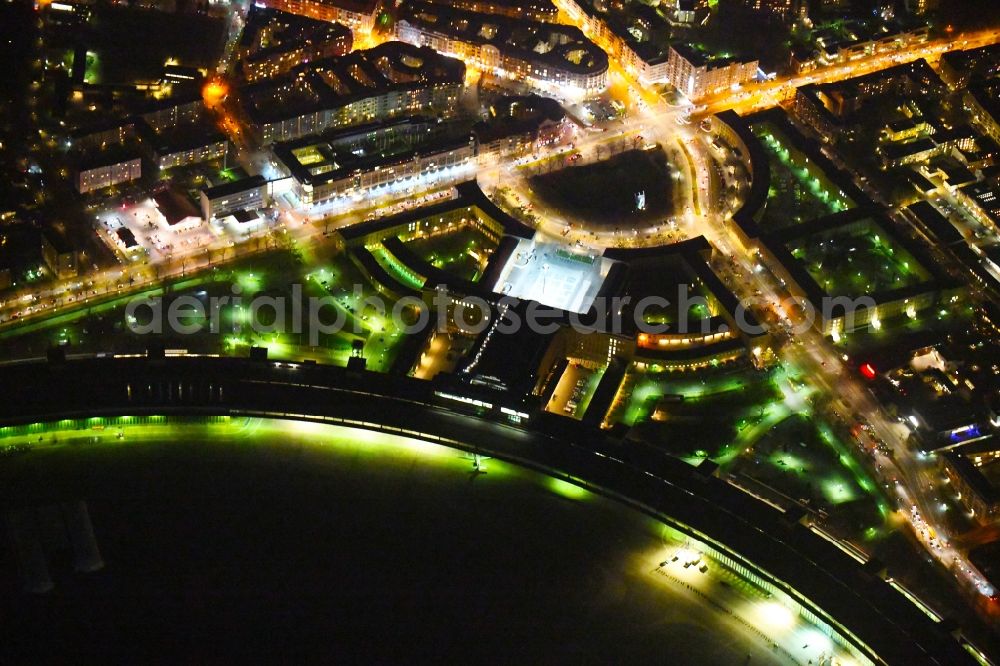 Aerial photograph at night Berlin - Night lighting Facade of the monument Flughafen Tempelhof on Platz of Luftbruecke in Berlin, Germany