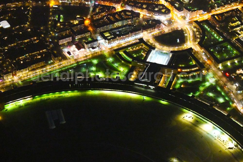 Aerial image at night Berlin - Night lighting Facade of the monument Flughafen Tempelhof on Platz of Luftbruecke in Berlin, Germany