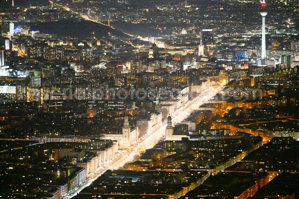 Aerial photograph at night Berlin - Night lighting street guide of famous promenade and shopping street Karl-Marx-Allee with the square at the Frankfurter Tor in the district Friedrichshain in Berlin, Germany