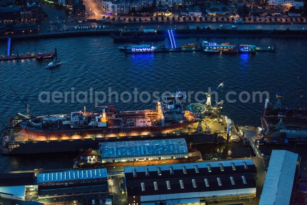 Aerial image at night Hamburg - View of overhaul and maintenance work on the research vessel Petrojarl Banff in dry dock of Blohm and Voss Dock Elbe in Hamburg. The dry dock Elbe 17 is one of the largest dry dock in Europe. It is located on the grounds of the Blohm + Voss shipyard in Hamburg harbor