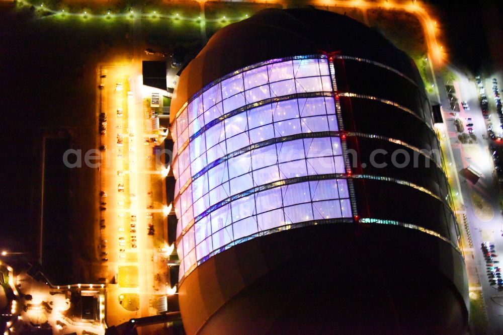 Aerial image at night Krausnick - Night lighting complete complex of the Theme Park Tropical Islands with air hall, outdoor pool, campsite, holiday homes and former airfield on street Tropical-Islands-Allee in Krausnick in the state of Brandenburg, Germany