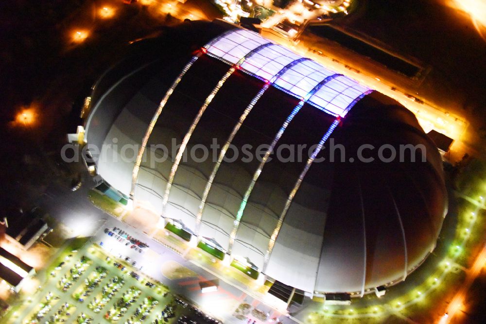 Krausnick at night from the bird perspective: Night lighting complete complex of the Theme Park Tropical Islands with air hall, outdoor pool, campsite, holiday homes and former airfield on street Tropical-Islands-Allee in Krausnick in the state of Brandenburg, Germany