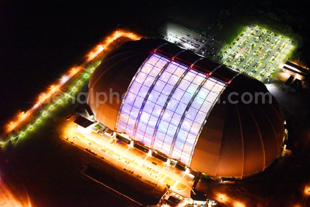 Aerial image at night Krausnick - Night lighting complete complex of the Theme Park Tropical Islands with air hall, outdoor pool, campsite, holiday homes and former airfield on street Tropical-Islands-Allee in Krausnick in the state of Brandenburg, Germany