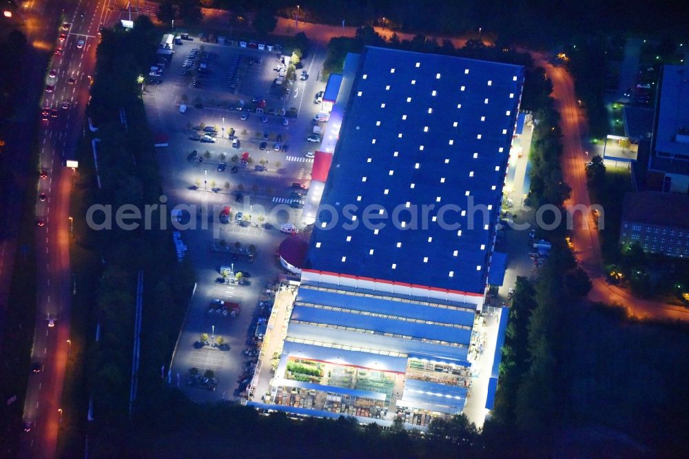 Aerial photograph at night Schwerin - Night lighting Building of the construction market of BAUHAUS Schwerin-Grosser Dreesch on Graf-Yorck-Strasse in Schwerin in the state Mecklenburg - Western Pomerania, Germany