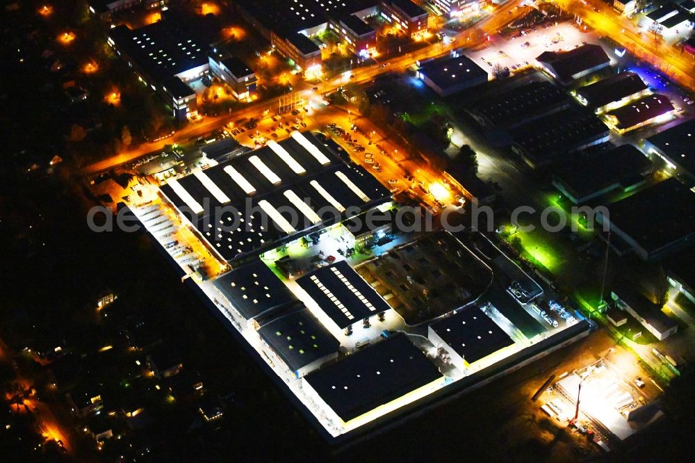 Aerial photograph at night Berlin - Night lighting Building of the construction market Holz Possling in the district Mahlsdorf in Berlin, Germany