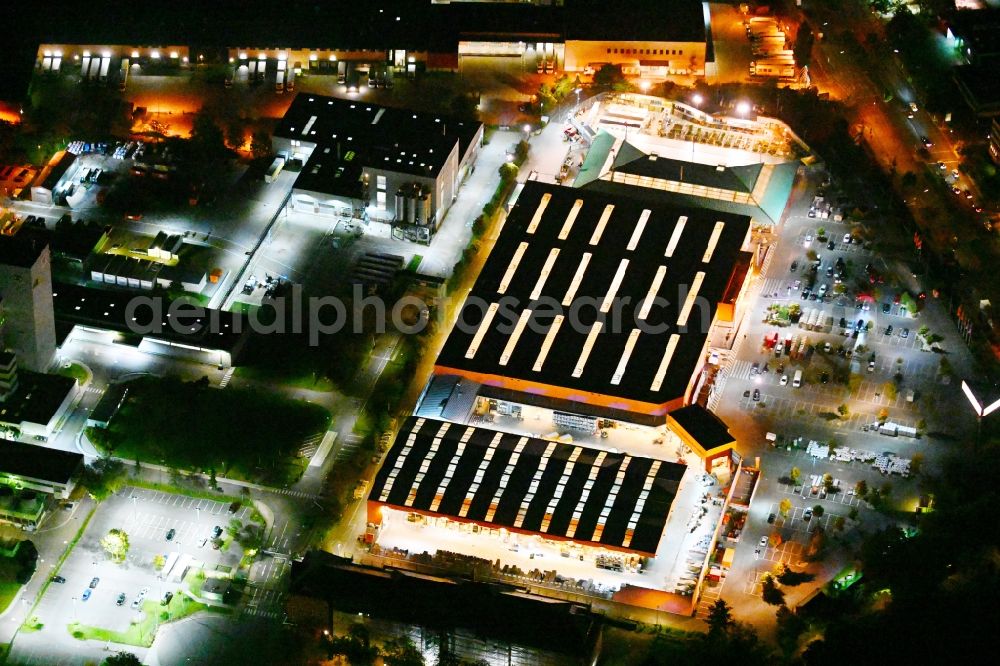 Aerial image at night Berlin - Night lighting building of the construction market HORNBACH on Gradestrasse in the district Britz in Berlin, Germany