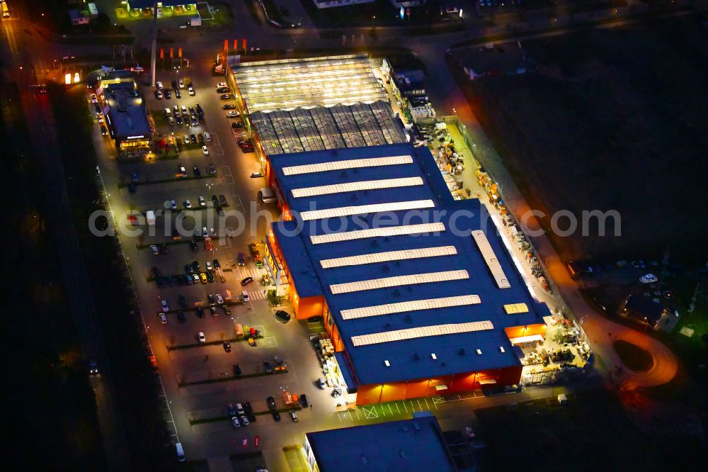 Bernau at night from the bird perspective: Night lighting building of the construction market OBI on J.-F.-A Johann-Friedrich-A.-Borsig-Strasse in Bernau in the state Brandenburg, Germany