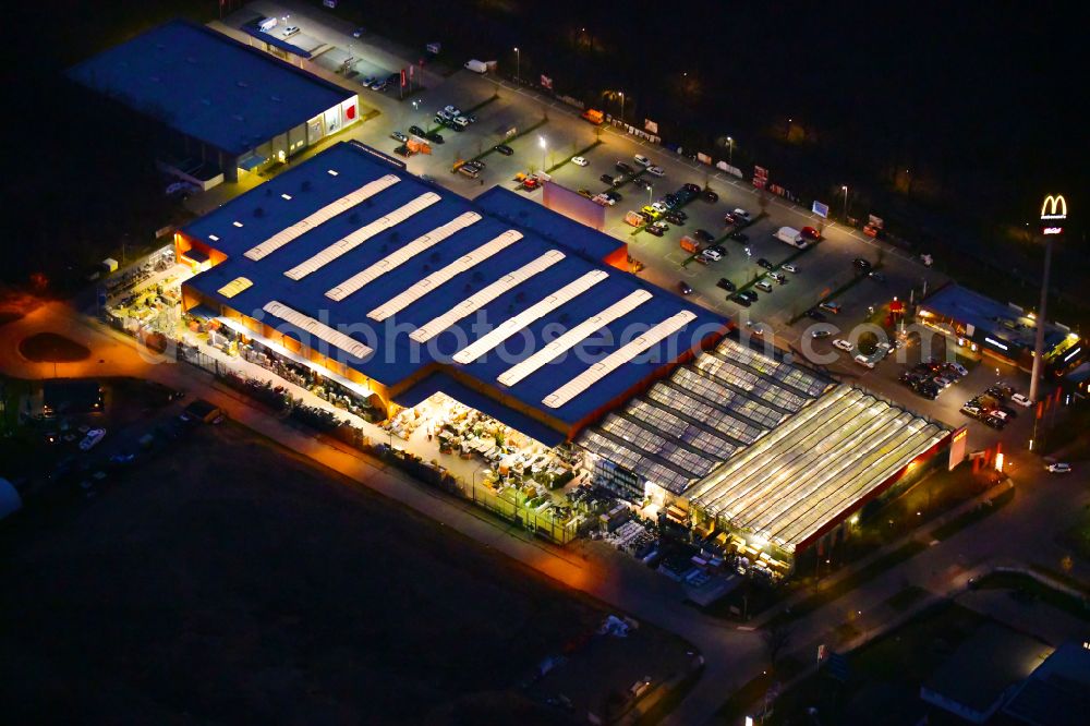 Bernau at night from the bird perspective: Night lighting building of the construction market OBI on J.-F.-A Johann-Friedrich-A.-Borsig-Strasse in Bernau in the state Brandenburg, Germany