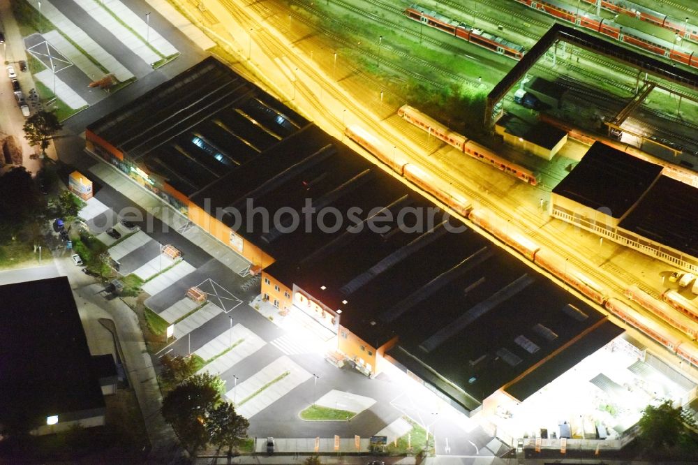 Berlin at night from the bird perspective: Night view building of the construction market of OBI Markt Berlin-Lichtenberg on Buchberger Str in Berlin