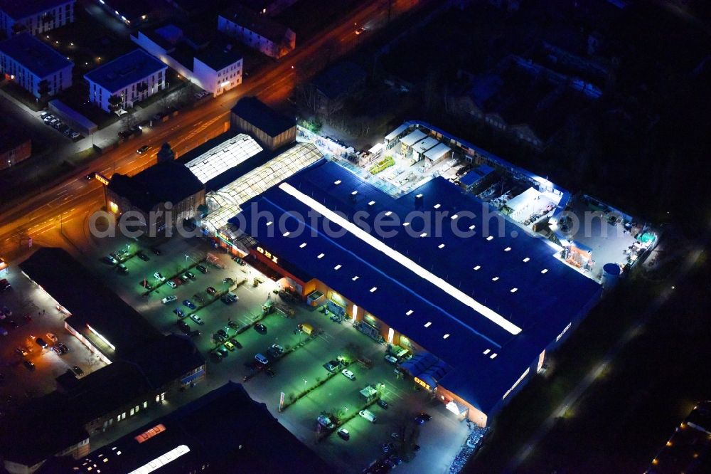 Aerial photograph at night Lutherstadt Wittenberg - Night lighting Building of the construction market of OBI Markt Wittenberg on Dessauer Strasse in Lutherstadt Wittenberg in the state Saxony-Anhalt