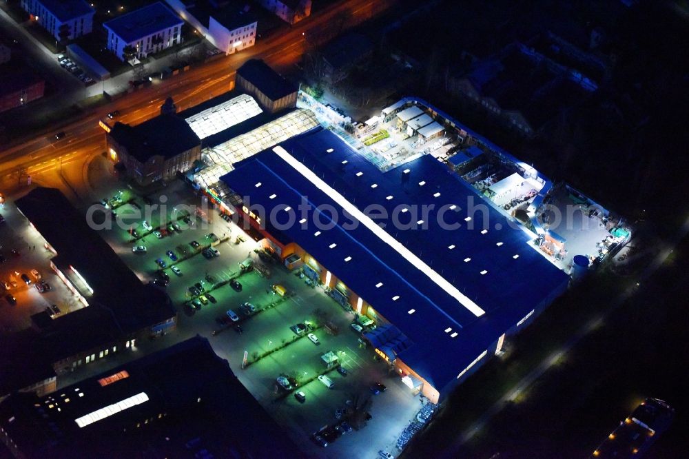 Aerial image at night Lutherstadt Wittenberg - Night lighting Building of the construction market of OBI Markt Wittenberg on Dessauer Strasse in Lutherstadt Wittenberg in the state Saxony-Anhalt