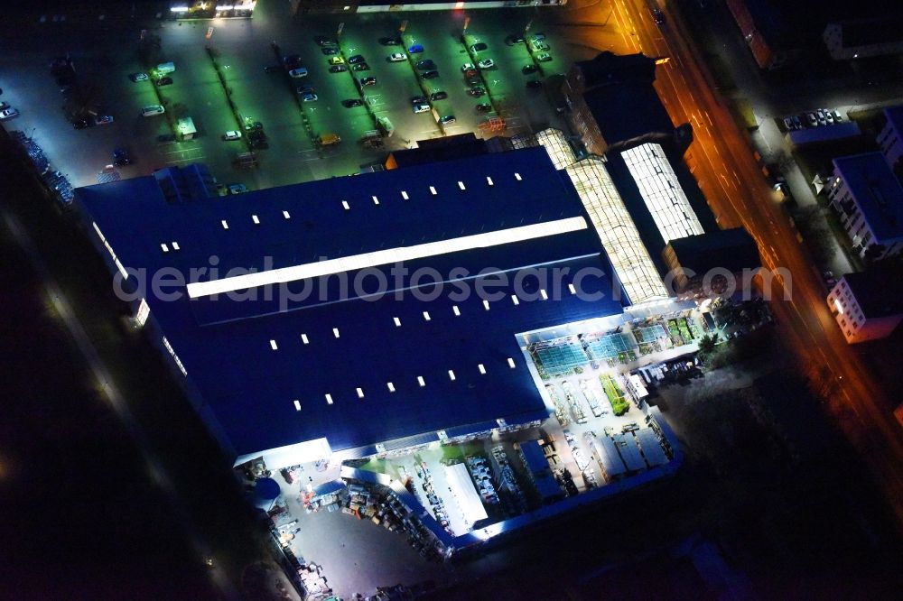 Aerial image at night Lutherstadt Wittenberg - Night lighting Building of the construction market of OBI Markt Wittenberg on Dessauer Strasse in Lutherstadt Wittenberg in the state Saxony-Anhalt