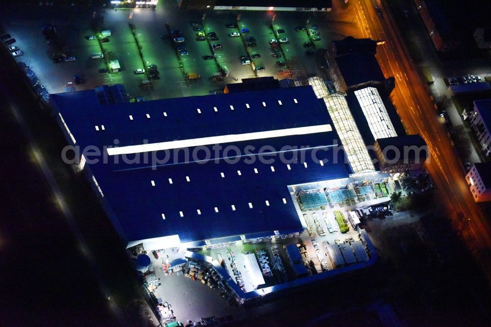 Lutherstadt Wittenberg at night from the bird perspective: Night lighting Building of the construction market of OBI Markt Wittenberg on Dessauer Strasse in Lutherstadt Wittenberg in the state Saxony-Anhalt