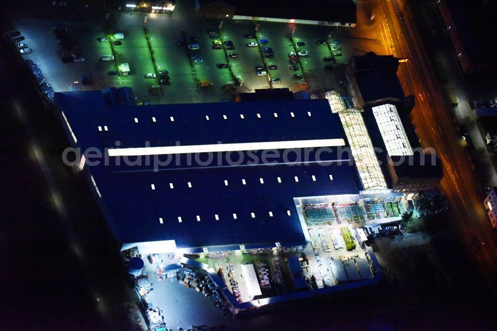 Aerial image at night Lutherstadt Wittenberg - Night lighting Building of the construction market of OBI Markt Wittenberg on Dessauer Strasse in Lutherstadt Wittenberg in the state Saxony-Anhalt