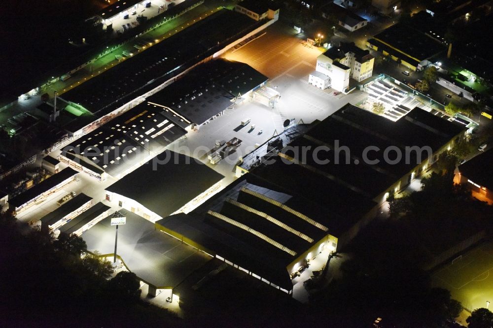 Berlin at night from the bird perspective: Night view building of the construction market of Possling GmbH & Co.KG Britz an der Haarlemer Strasse in Berlin