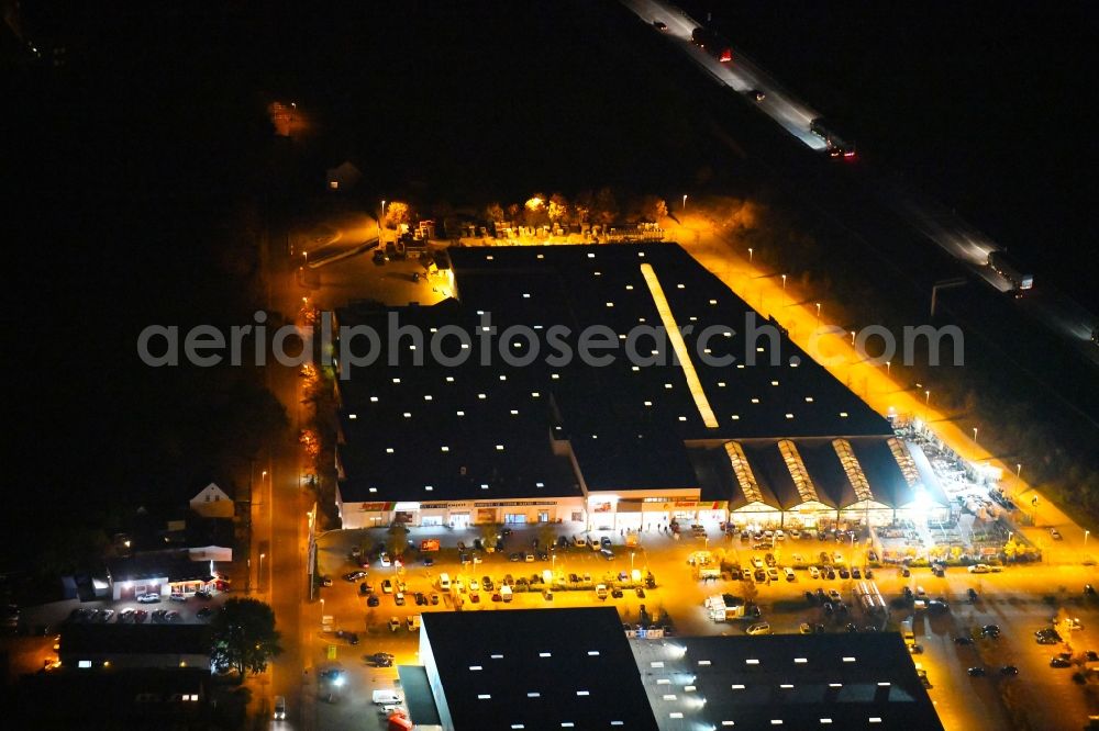 Fürstenwalde/Spree at night from the bird perspective: Night lighting Building of the construction market toom on Alte Langewahler Chaussee in Fuerstenwalde/Spree in the state Brandenburg, Germany