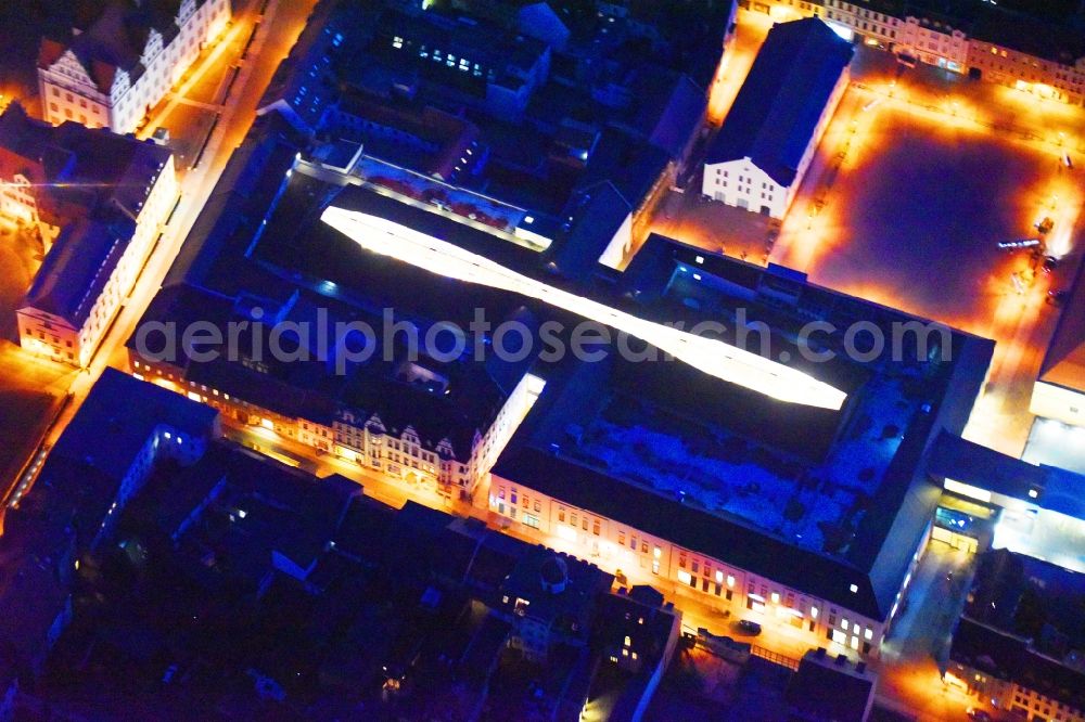 Lutherstadt Wittenberg at night from the bird perspective: Night lighting Building of the shopping center ARSENAL in Lutherstadt Wittenberg in the state Saxony-Anhalt